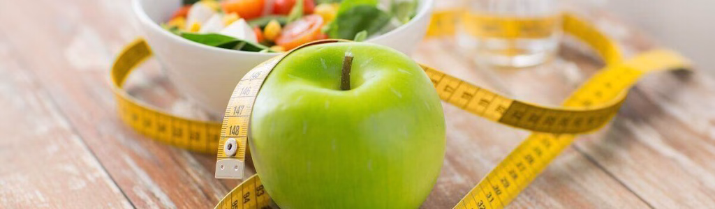 ثمرة تفاح اخضر و طبق من السلطة الطازجة ضمن نظام غذائي متوازن لخسارة 5 كيلو في شهر