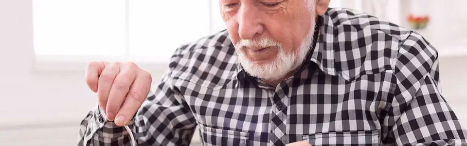 رجل كبير في السن يتناول طعامه بصعوبة لانه يعاني من اعراض فقدان الشهية عند كبار السن