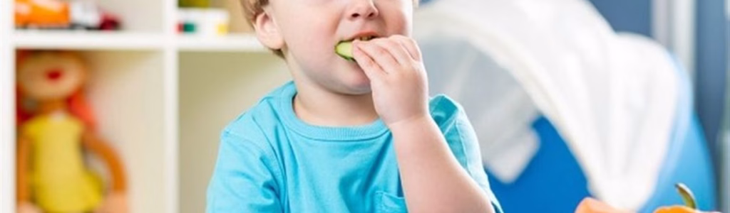 طفل يتناول طعامه الغني بأهم الفيتامينات لنمو الأطفال